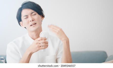 
A Man Cooling With A Handy Fan