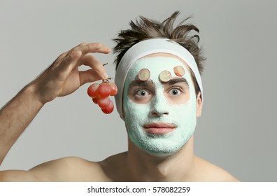 Man with cosmetic mask on face, gray background