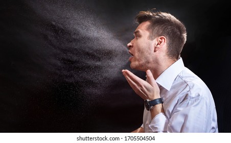 Man Is Coughing Trying To Cover His Mouth.  Influenza, Cold, Flu, Coronavirus. Infection Through An Airborne Droplet. Droplets Of Saliva, Water And Viruses. Cough And Sneeze. Man 30-40 Aged