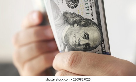 Man counting american dollars banknotes, close up view - Shutterstock ID 2209929025