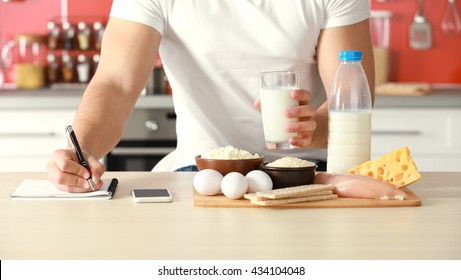 Man Counting Calories On Table