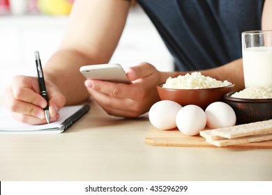 Man counting calories on table - Shutterstock ID 435296299
