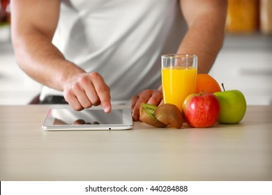 Man Counting Calories On Tablet