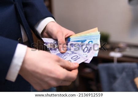  man is counting canadian dollars. Concept showing Canadian economy, investing and finance
