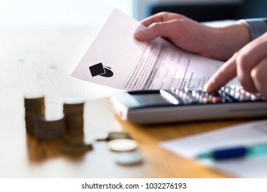 Man counting college savings fund, tuition fee or student loan with calculator. Education price and expenses concept. Money and papers on table. Calculating budget and planning finance.