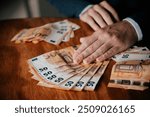 Man counting euro banknotes. Businessman counting money on wooden table.