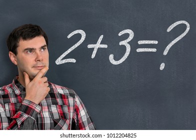Man is counting a mathematical task on blackboard - education concept