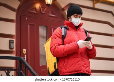 Man courier using a map app on mobile phone to find the delivery address in the city. Courier delivery food service at home. Courier man using smartphone. Stock photo