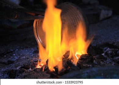 Man covering copper object with fiery tin, traditional Turkish tin
