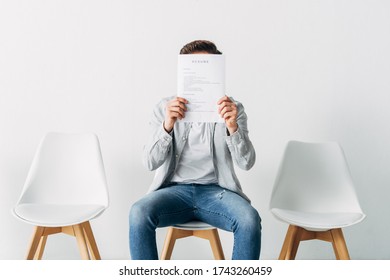 Man Covering Face With Resume In Office