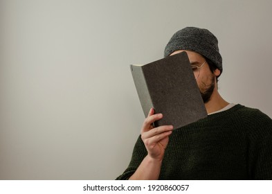 Man Covering His Face With A Gray Task Book