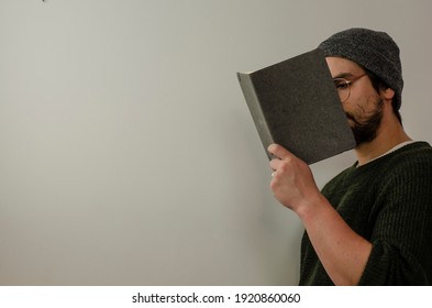 Man Covering His Face With A Gray Task Book