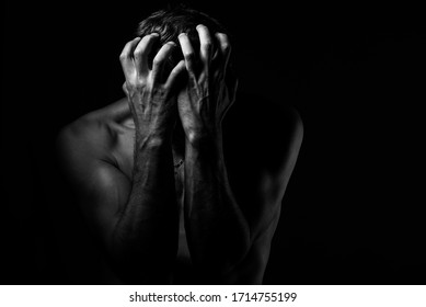 Man Covers His Face With His Hands. Regret Or Fear. On A Dark Background. Black And White Photography.