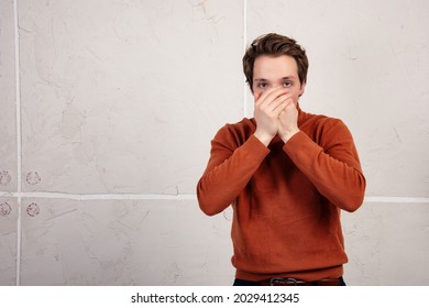 The Man Covers His Mouth With His Palm. Do Not Speak Evil. Guy On A White Background.