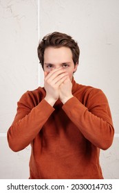 The Man Covers His Mouth With His Palm. Do Not Speak Evil. Guy On A White Background.