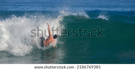 Man crashing into the sea. He Falls from the surfboard, a surfing accident on a high powerful wave.