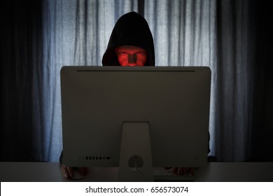 Man with criminal intentions at a desktop computer on the internet.
