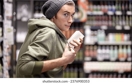 Man, criminal or steal or food in supermarket crime, poverty or hungry homeless sneak. Male person, thief or hide product or shoplifting in grocery shopping store for addiction money, sell or secret