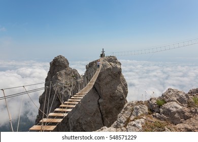 Man Crossing The Chasm On The Hanging Bridge (focus On The Middle Of Bridge)