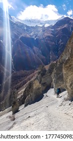 A Man Crossing A Dangerous Passage Along The Landslide Area On The Way To Tilicho Base Camp, Annapurna Circus, Himalayas, Nepal. Dry And Desolated Landscape. Steep And Sharp Slopes. Extreme Trekking