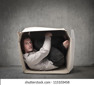 Man crouched in a box