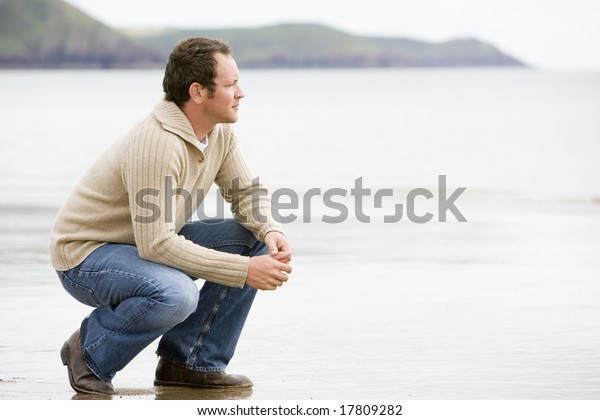 浜辺でしゃがむ男 の写真素材 今すぐ編集