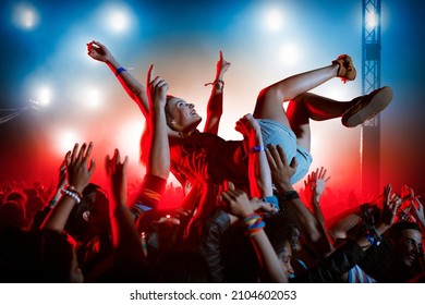 Man crowd surfing at music festival - Shutterstock ID 2104602053