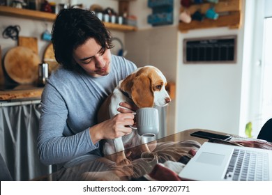 Man Cuddle With His Dog In Kitchen At Home