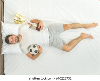 The Man With A Cup And A Ball Sleeping In The Bed. View From Above