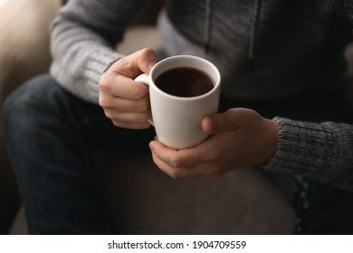A man with a cup of coffee. A man drinks coffee sitting near the window - Shutterstock ID 1904709559