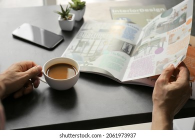 Man with cup of coffee reading magazine in office - Powered by Shutterstock