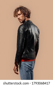 Man With Curly Hair Wearing Laser Jacket Studio Standing Isolated On Bage Background Back View Looking Camera Curious