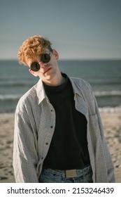 A Man With Curly Red Hair On His Head, In Round Dark Glasses, Looks At The Camera, In A Shirt