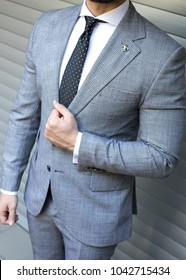 Man In Custom Tailored Suit Posing In Front Of Background