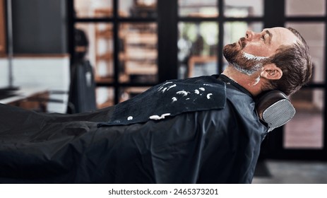 Man, customer and beard care in barbershop, wash and trim or neat facial line up for client in all purpose chair. Appointment, maintenance and fresh cut with male person, wellness and relaxing - Powered by Shutterstock