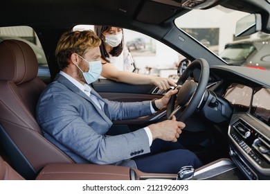 Man Customer Buyer Client Wear Grey Suit Pandemic Masks Drive Car Choose Auto Want Buy New Automobile In Showroom Consult With Salesman Vehicle Salon Dealership Store Motor Show Indoor Sale Concept