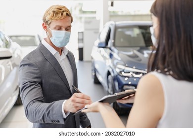 Man Customer Client Buyer In Classic Suit Pandemic Mask Choose Auto Want Buy New Car Automobile Consult With Salesman Sign Agreement In Showroom Salon Dealership Store Motor Show Indoor Sale Concept