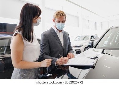 Man Customer Male Client Buyer In Suit Pandemic Mask Choose Auto Want Buy New Car Automobile Consult With Salesman Sign Papers On Hood In Showroom Salon Dealership Store Motor Show Indoor Sale Concept