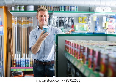 Man Customer Picking Paint Tin In Household Store