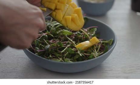 Man Cut Mango In Salad With Micro Greens In Blue Bowl, Wide Photo