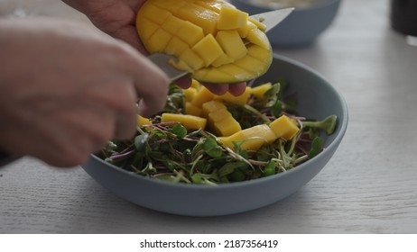 Man Cut Mango In Salad With Micro Greens In Blue Bowl, Wide Photo