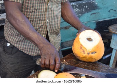 Man Cuts Coconut At Caribbean Market