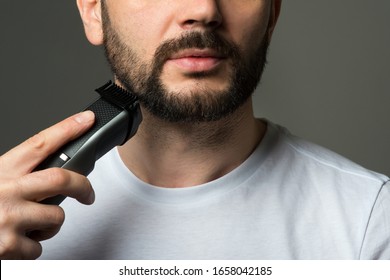 Man Cuts His Beard With A Trimmer