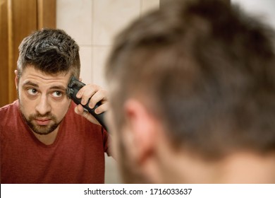 A Man Cuts His Hair On His Head With An Electric Razor 