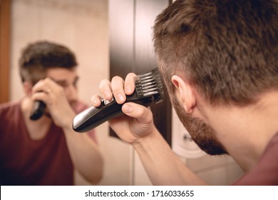 A Man Cuts His Hair On His Head With An Electric Razor 