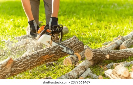 A man cuts logs with a saw outdoors. 