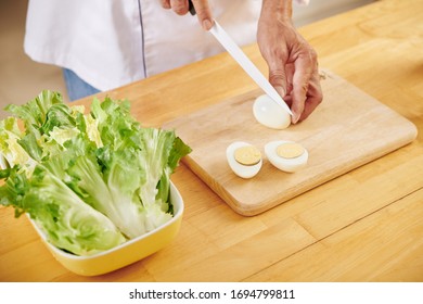 Man Cutting Boiled Eggs When Making Caesar Salad At Home