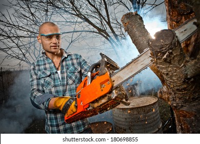 Man Cutting A Branch With Chainsaw