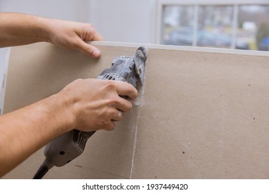 Man Cutting Gypsum Drywall Board On Using Angle Hand Electric Power Tools