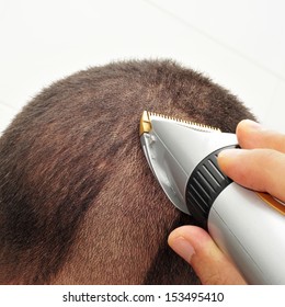 A Man Man Cutting His Hair With An Electric Hair Clipper